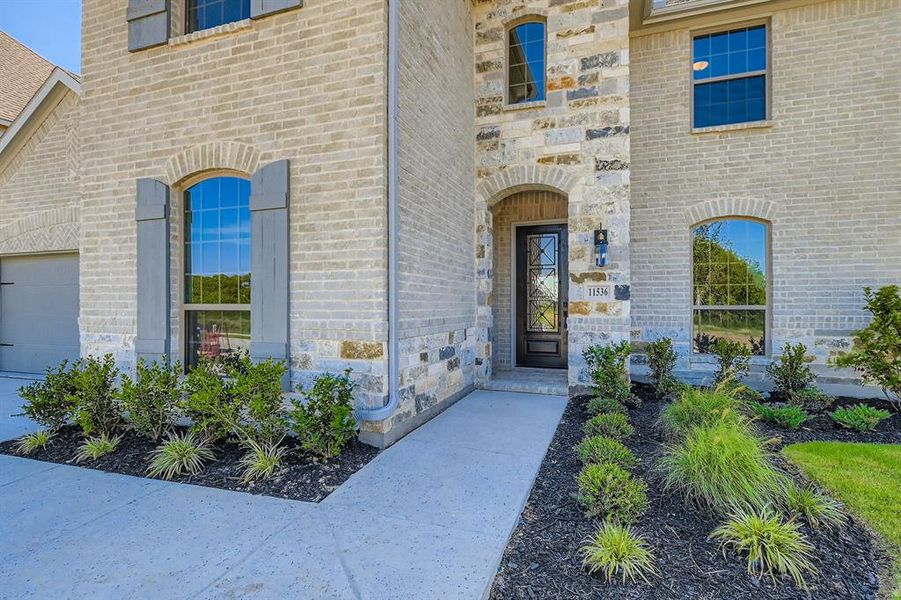 Doorway to property with stone siding and brick siding