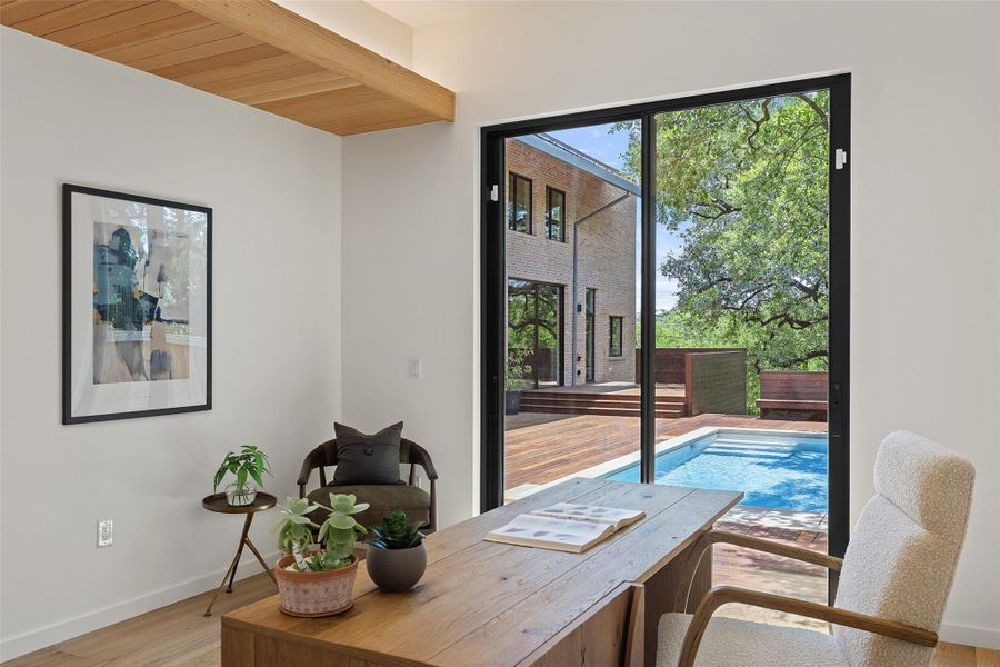 Office space with light wood-type flooring and wood ceiling