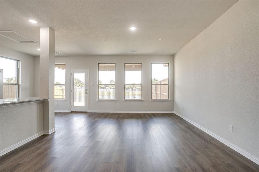 Unfurnished room with dark wood finished floors, a textured wall, a textured ceiling, and recessed lighting