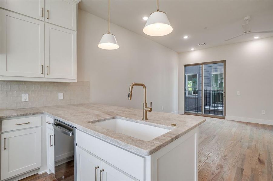 Gourmet kitchen with gas range, quartzite island, and dramatic pendant lighting for a refined modern aesthetic. Gourmet kitchen with gas range, quartzite island, and dramatic pendant lighting for a refined modern aesthetic.