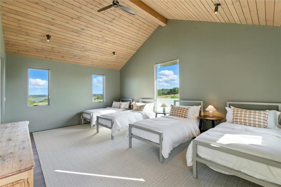 Bedroom featuring high vaulted ceiling, multiple windows, a wood ceiling with exposed beams, and a ceiling fan