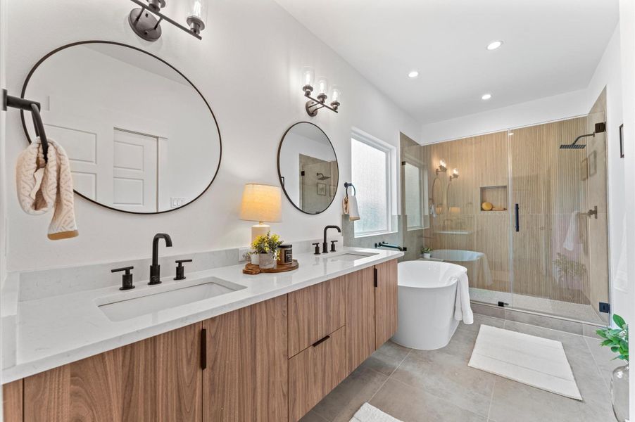 This luxurious primary bathroom blends modern elegance with spa-like comfort, featuring a spacious layout and contemporary selections throughout. A sleek double vanity with minimalist cabinetry and polished countertops offers ample storage and style, while the glass-enclosed shower includes a built-in bench for added relaxation and convenience. The centerpiece is a sculptural freestanding soaking tub, perfectly positioned to invite unwinding after a long day. This luxurious primary bathroom blends modern elegance with spa-like comfort, featuring a spacious layout and contemporary selections throughout. A sleek double vanity with minimalist cabinetry and polished countertops offers ample storage and style, while the glass-enclosed shower includes a built-in bench for added relaxation and convenience. The centerpiece is a sculptural freestanding soaking tub, perfectly positioned to invite unwinding after a long day.