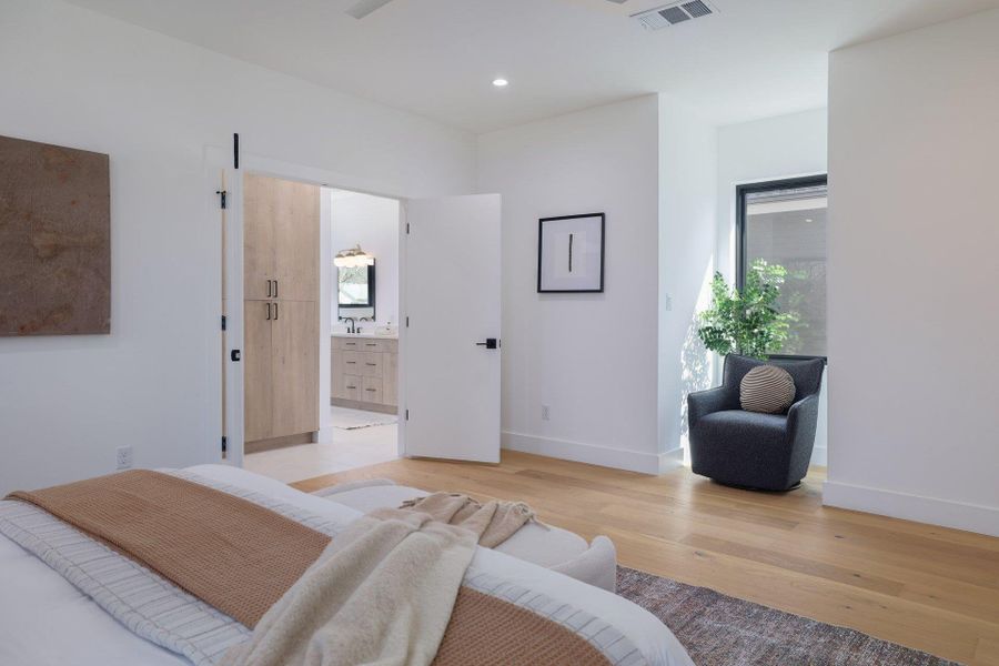 Bedroom featuring light wood finished floors, multiple windows, recessed lighting, a ceiling fan, and connected bathroom