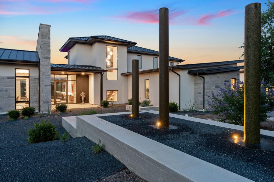 Spanning an impressive 9,438 sq ft, this modern masterpiece seamlessly blends with the majestic landscape, boasting exquisite professional landscaping with native plants, xeriscape pathways, and serene water sculptures