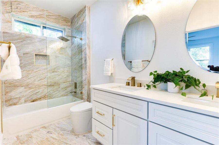 Full bathroom featuring vanity, toilet, and tiled shower / bath combo