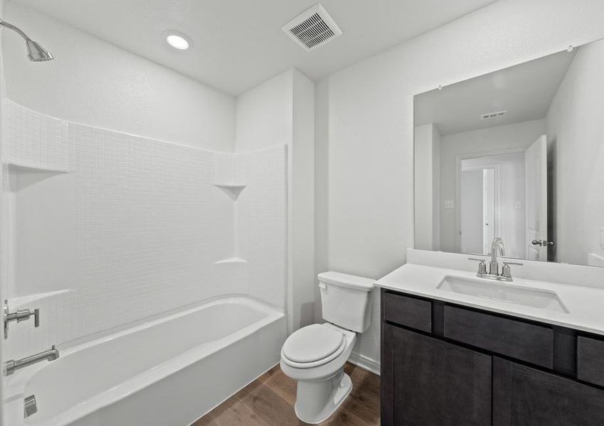 The secondary bathroom has a large vanity space and a shower-tub combo.