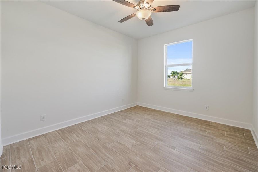 Empty room with wood finish floors and a ceiling fan