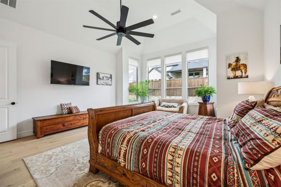 Bedroom featuring wood finished floors, vaulted ceiling, recessed lighting, a ceiling fan, and baseboards