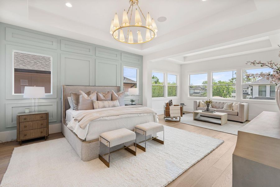 The primary suite offers a true retreat with expansive proportions, large windows, and a sitting area, all enhanced by elevated ceiling details and designer lighting.