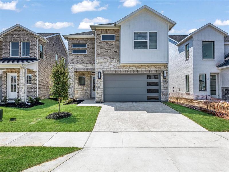 View of front of property featuring concrete driveway, stone siding, a garage, and a front yard View of front of property featuring concrete driveway, stone siding, a garage, and a front yard