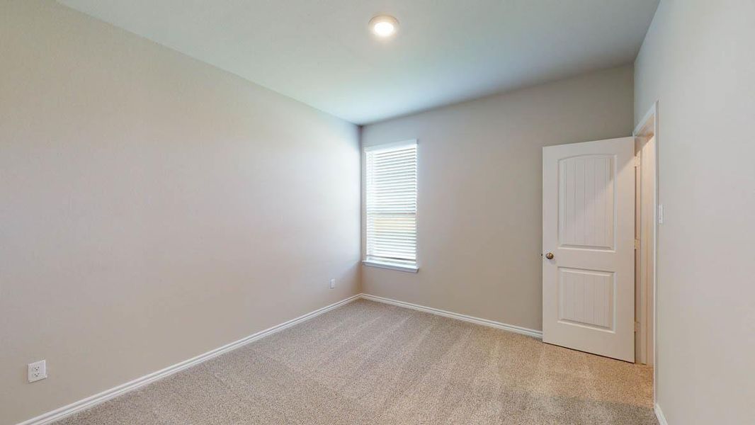 Spare room featuring light colored carpet and baseboards