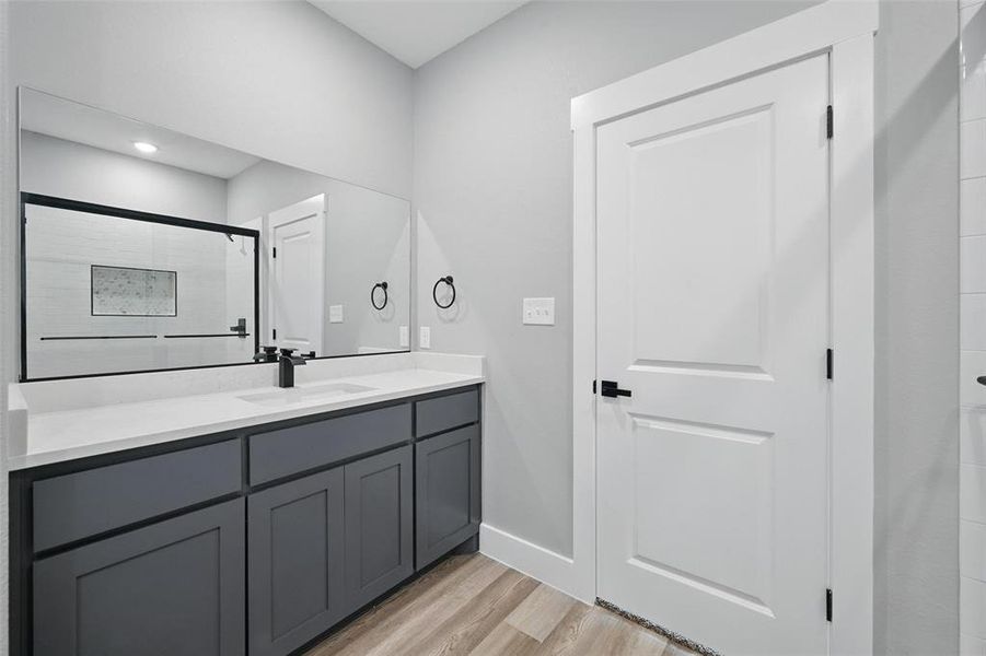 Bathroom with wood finished floors, baseboards, and vanity
