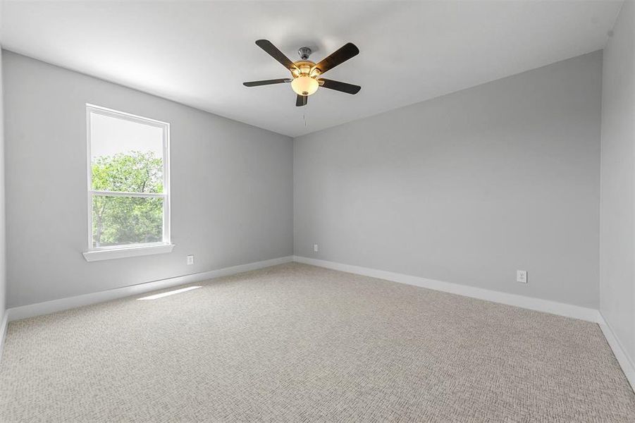 Empty room with carpet flooring and ceiling fan