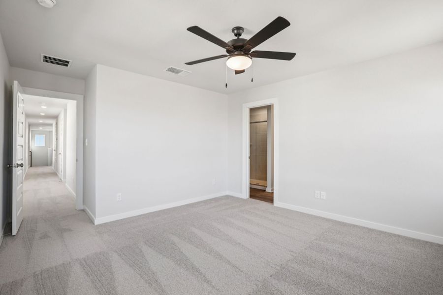 A room with a ceiling fan and a door.