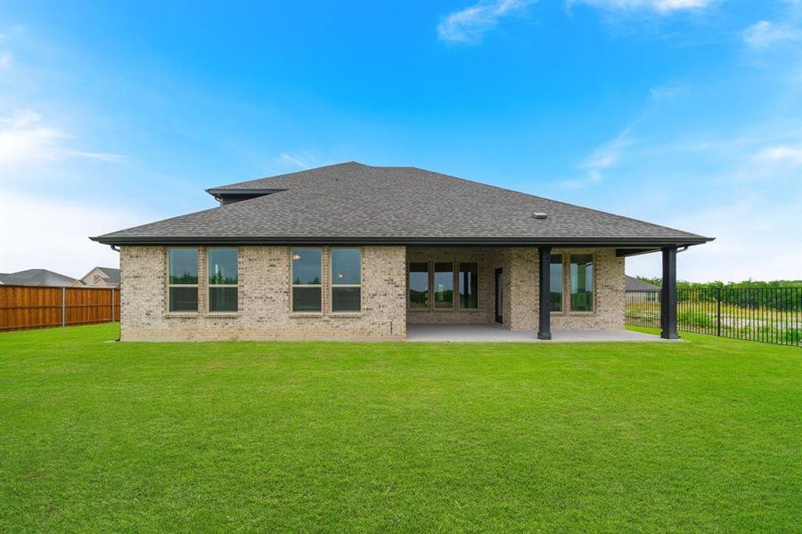 Back of property featuring a yard and a patio