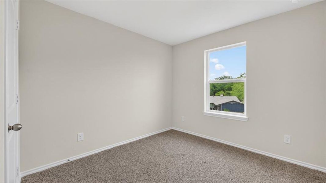 Carpeted interior room with light neutral walls and white trim