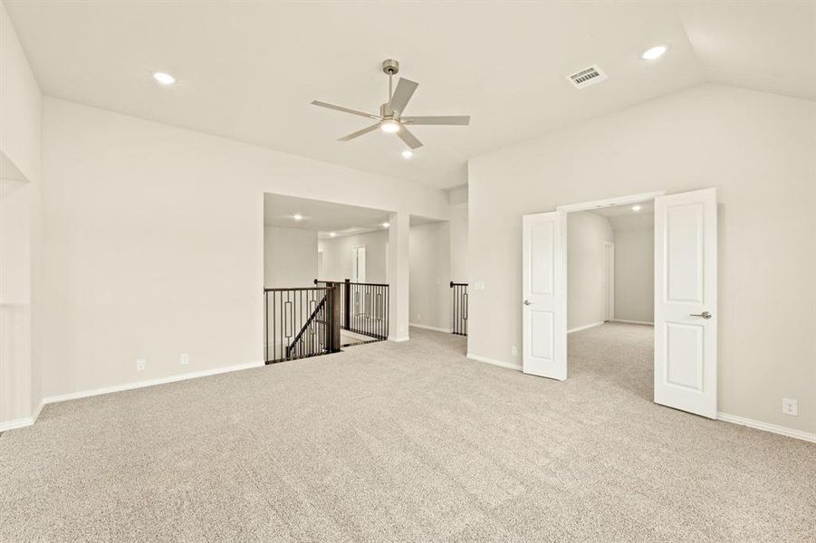 Spare room featuring light carpet, recessed lighting, a ceiling fan, and lofted ceiling