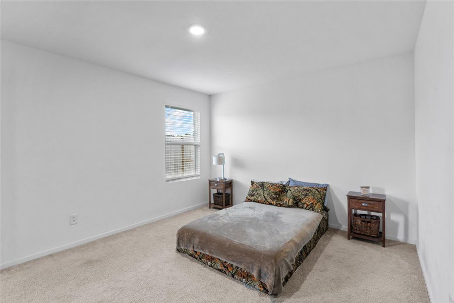 Spacious primary bedroom with plenty of room for a comfortable bedroom setup.
