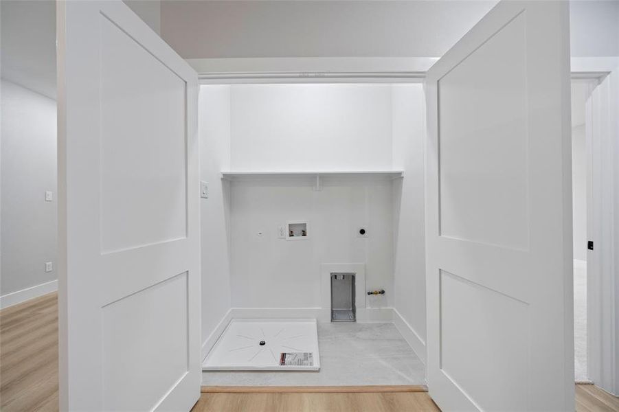 Laundry room with electric dryer hookup, washer hookup, light wood-style flooring, a fireplace, and laundry area