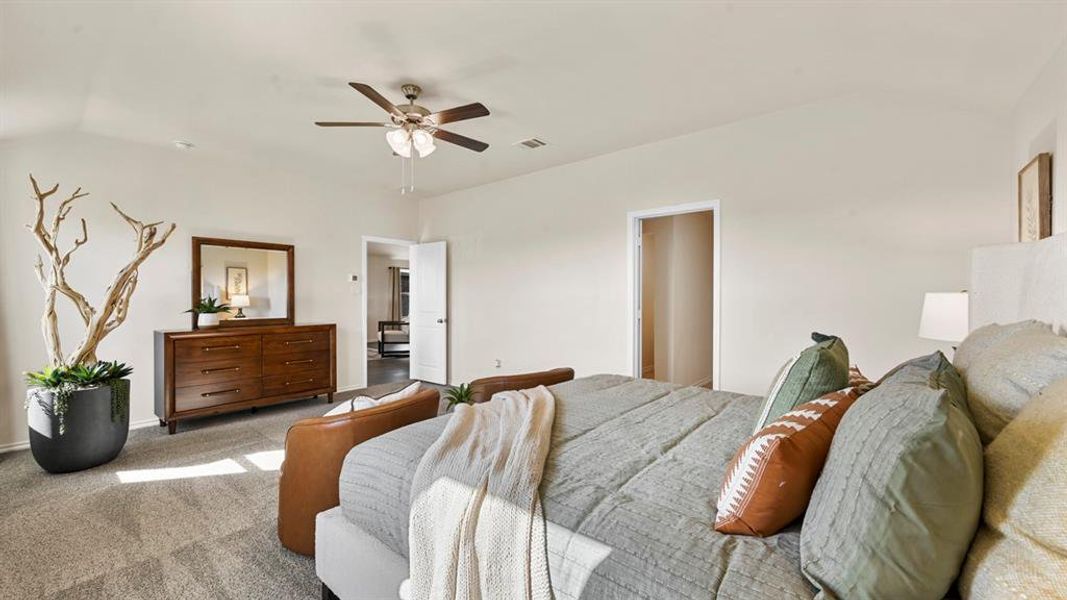 Bedroom featuring vaulted ceilings, carpeted flooring, and a ceiling fan