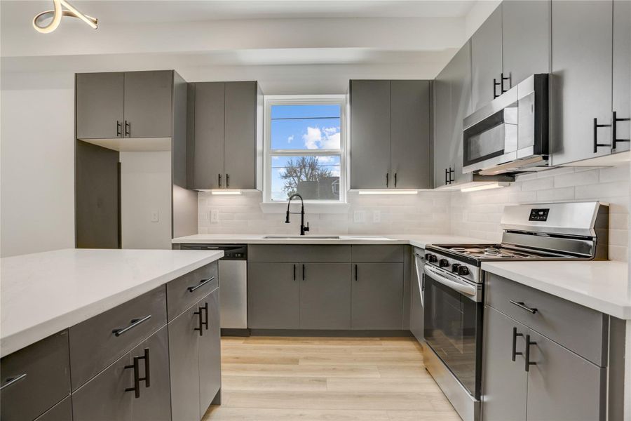 The kitchen has under cabinet lighting and subway tile backsplash.