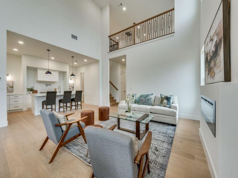 Living room with a towering ceiling and light wood-type flooring