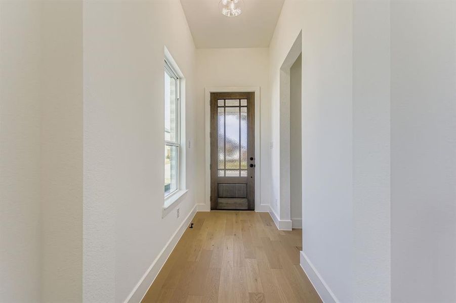 Doorway to outside with baseboards and wood finished floors Doorway to outside with baseboards and wood finished floors