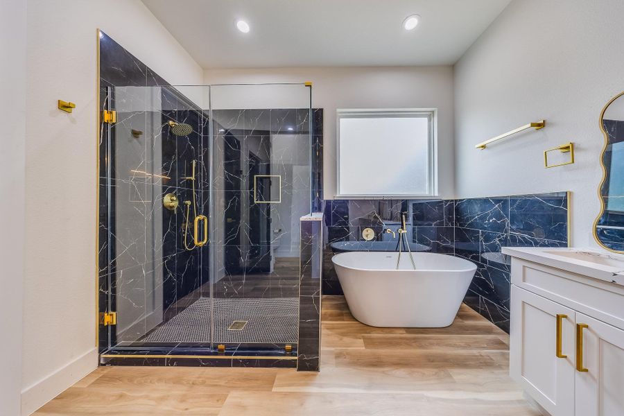 Primary bath showcases blue luxury tile with elegant gold touches, creating a sophisticated, spa-like retreat with modern charm.