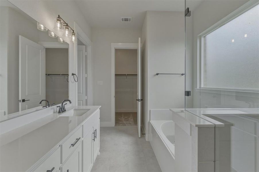Contemporary bathroom featuring a dual vanity with quartz countertops, undermount sinks, and matte black fixtures Contemporary bathroom featuring a dual vanity with quartz countertops, undermount sinks, and matte black fixtures