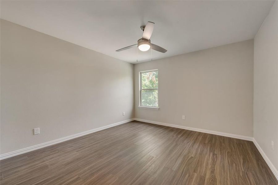 Spare room with dark hardwood / wood-style floors and ceiling fan