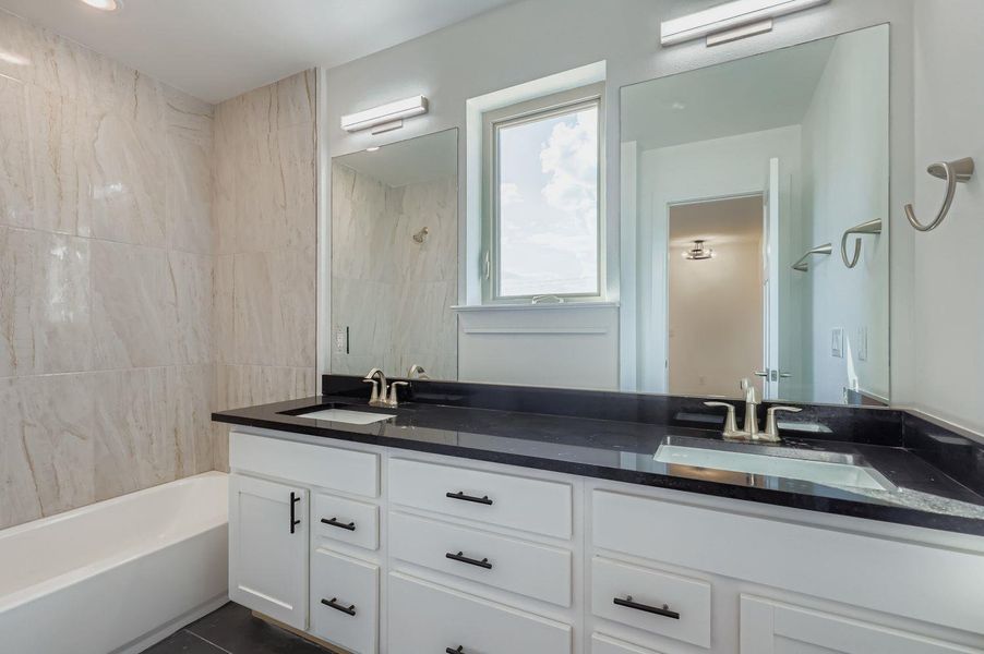 Bathroom featuring double vanity and bathtub / shower combination