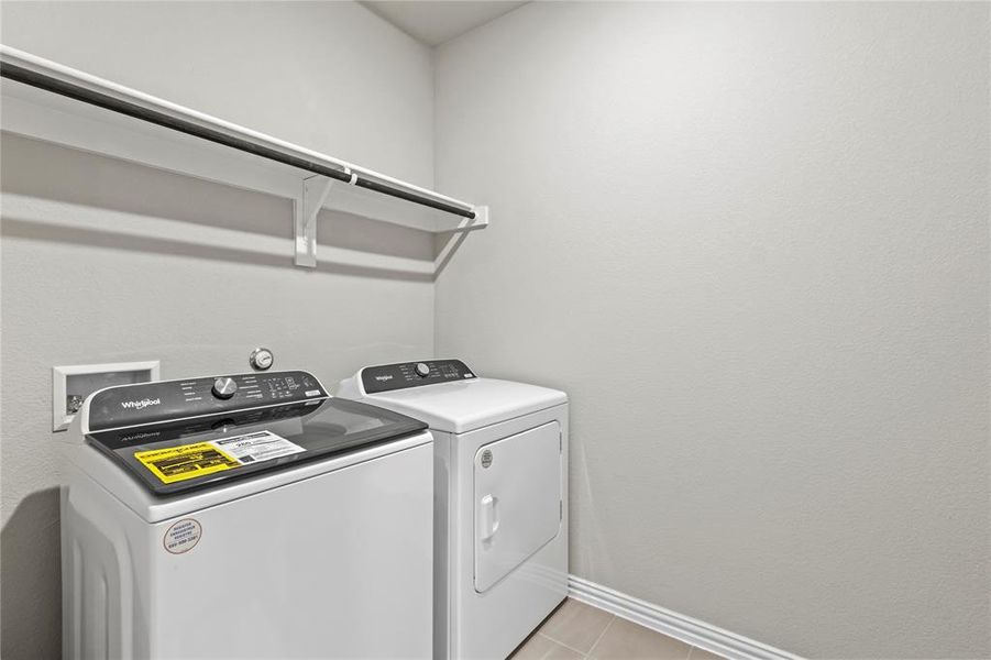 Washroom featuring washing machine and dryer and light tile patterned flooring Washroom featuring washing machine and dryer and light tile patterned flooring