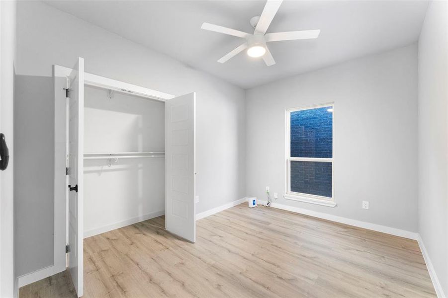 Unfurnished bedroom featuring light wood-type flooring, a ceiling fan, and a closet