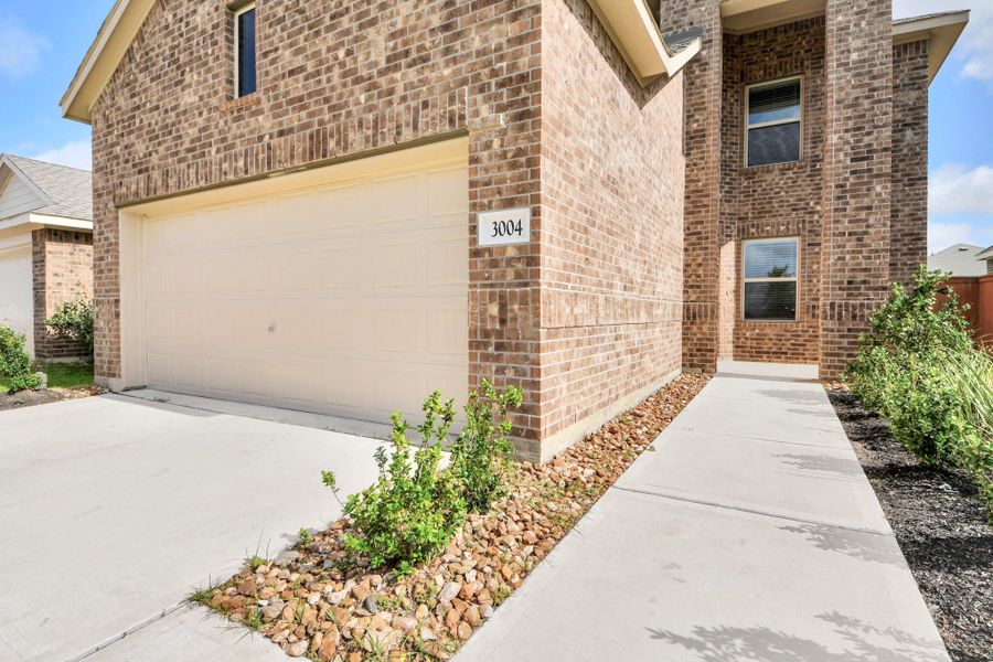 Welcoming covered entry with clean landscaping.