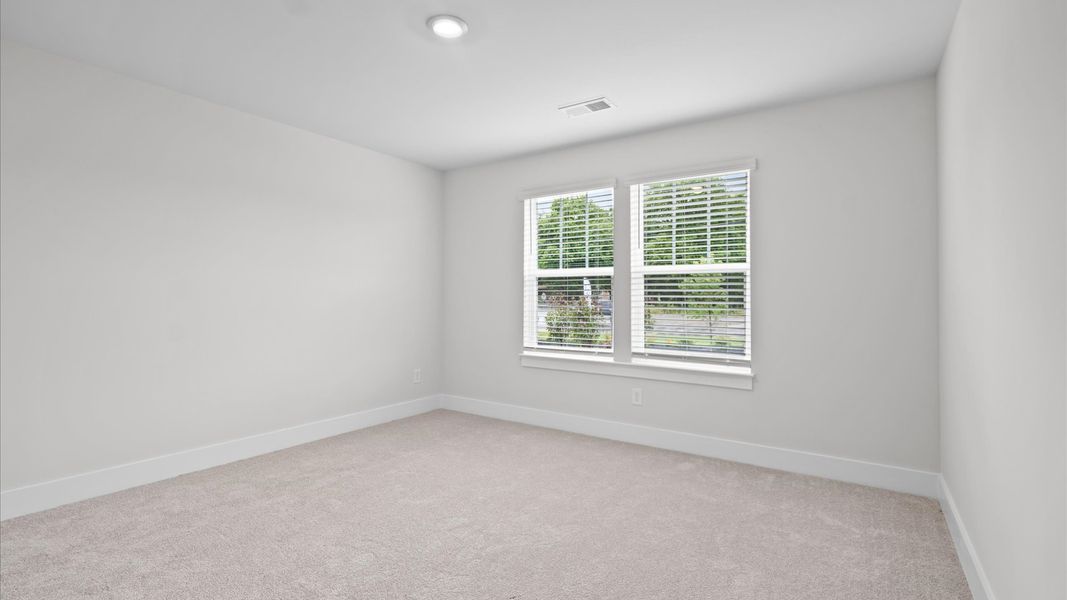 Accomplished design shines in this carpeted bedroom with walk-in closet at Silo Ridge by DRB Homes in Anderson, SC