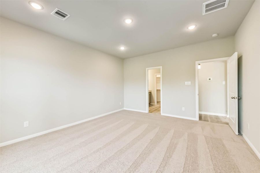 Alternate view of the primary bedroom leading into the primary bathroom.