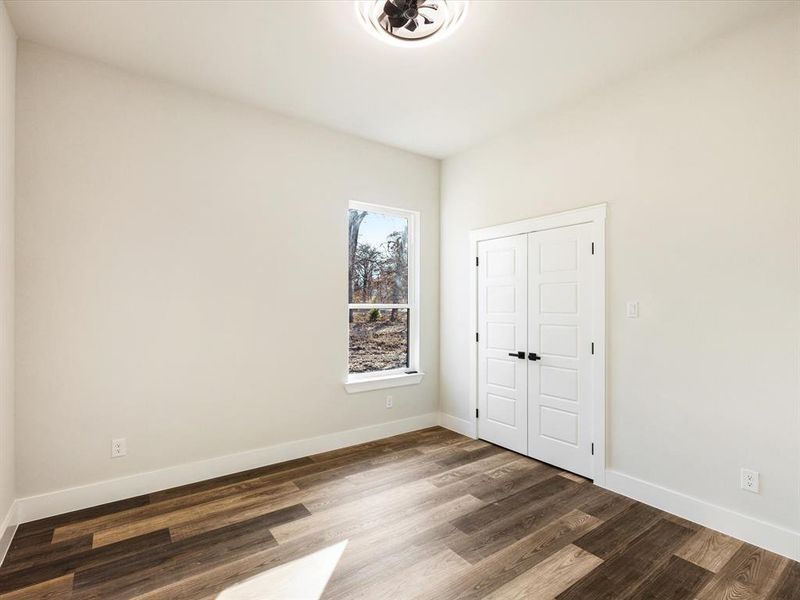 Unfurnished bedroom featuring wood finished floors and a closet