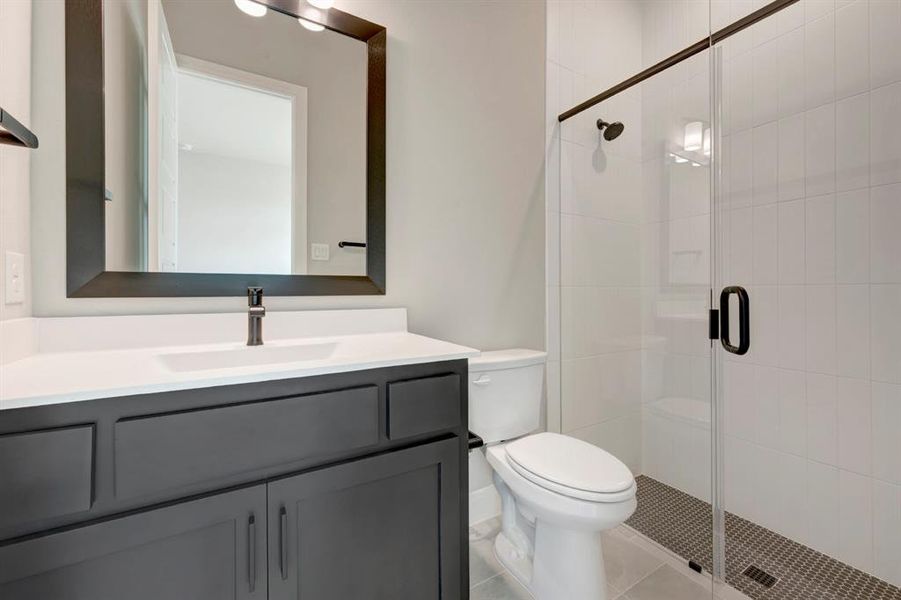 Full bathroom with vanity, a stall shower, and light tile patterned floors Full bathroom with vanity, a stall shower, and light tile patterned floors