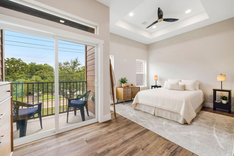 Spacious primary suite featuring a tray ceiling, private balcony access, and plenty of natural light. Spacious primary suite featuring a tray ceiling, private balcony access, and plenty of natural light.