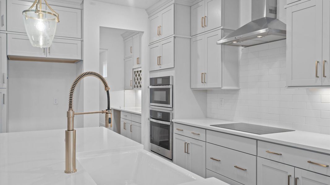 Elegant kitchen with large island and pendant lighting in this first-class DRB Homes design