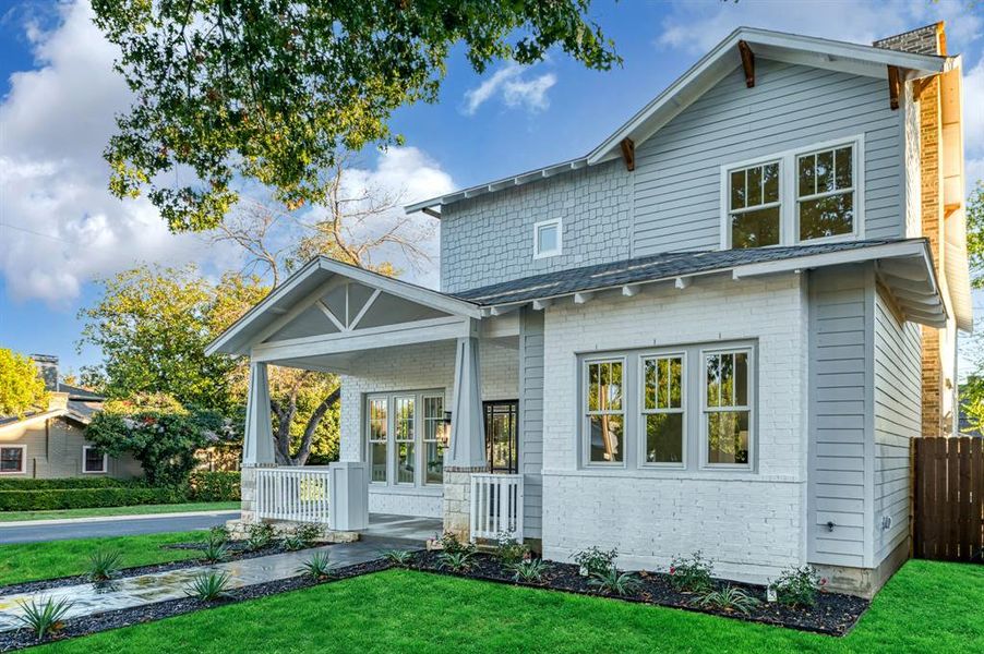 Back of property featuring a porch and a yard