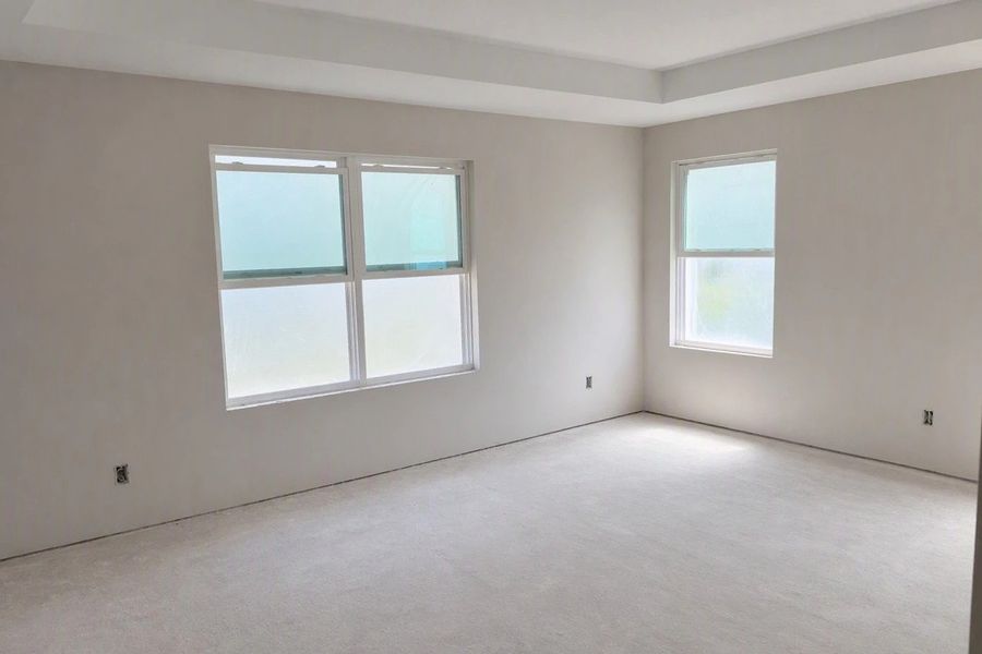 Primary bedroom featuring a tray ceiling - under construction
