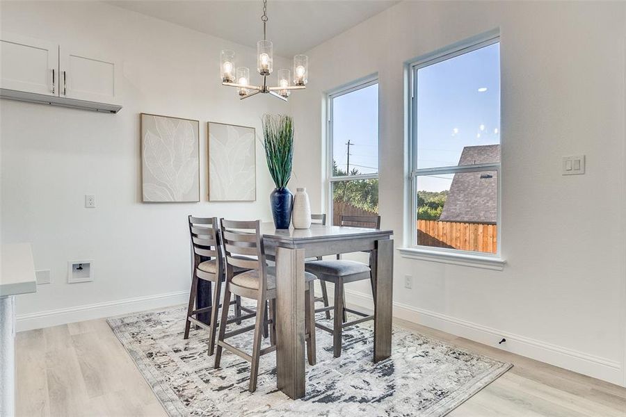 Dining space with light wood-style floors and a chandelier Dining space with light wood-style floors and a chandelier
