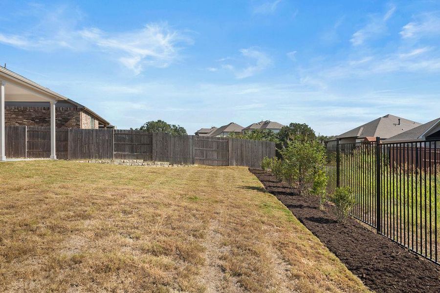To the left in the backyard, with green space buffer zone