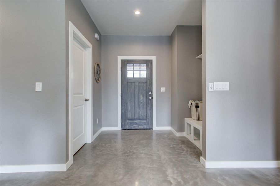 Foyer entrance featuring concrete floors and baseboards