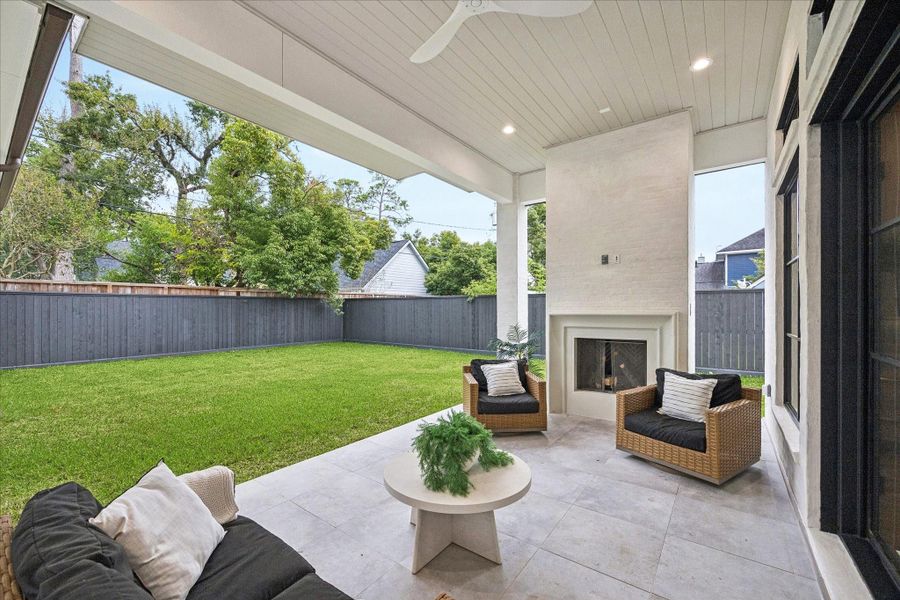 A clean-lined fireplace, high ceilings, and generous covered space create a year-round outdoor lounge. Spray foam roofline enhances temperature control even in peak summer.