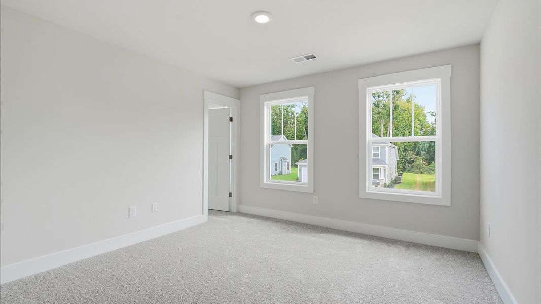 Vibrant and inviting secondary bedroom featuring a walk-in closet and refined finishes