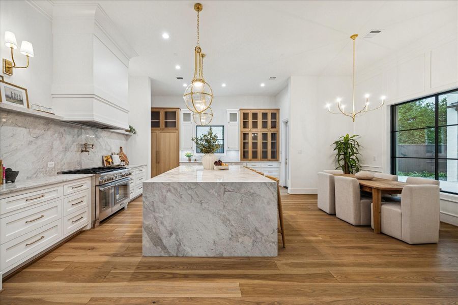 A striking Montebello stone island centers the kitchen with seating and additional storage. The kitchen is supported by a Thermador appliance package. Brass accents and white oak cabinetry complete the warm, elevated palette.
