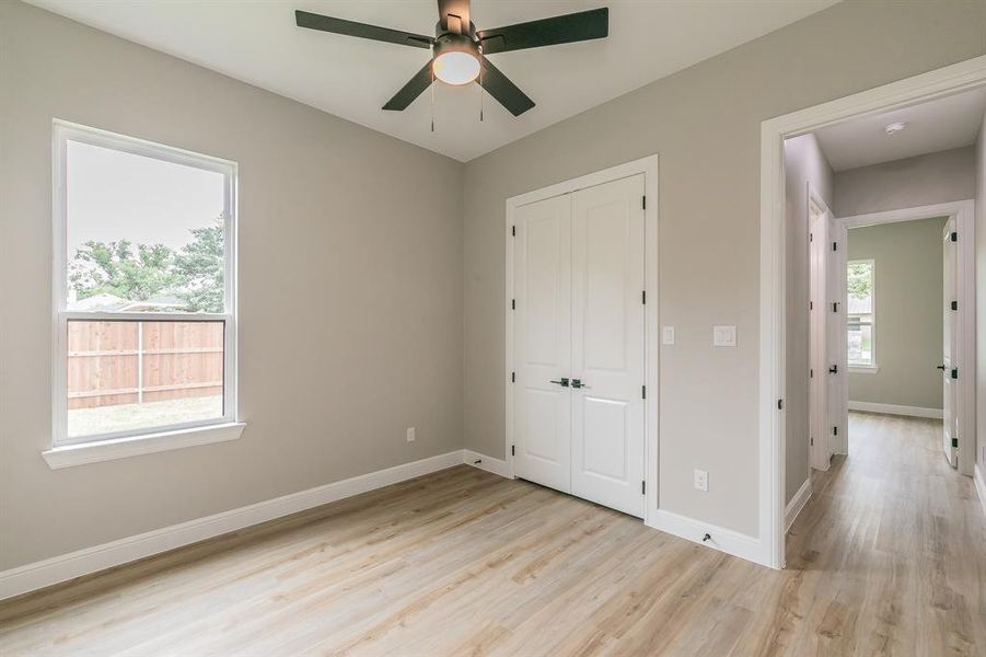 Unfurnished bedroom with light wood-style flooring, a closet, and baseboards Unfurnished bedroom with light wood-style flooring, a closet, and baseboards