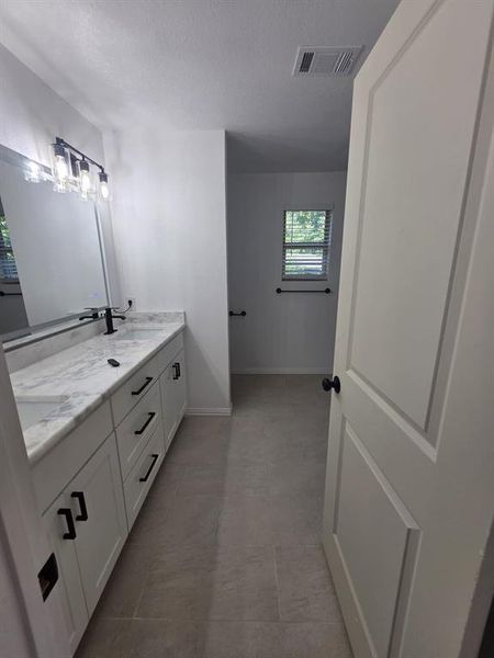 Full bath featuring double vanity and a textured ceiling Full bath featuring double vanity and a textured ceiling